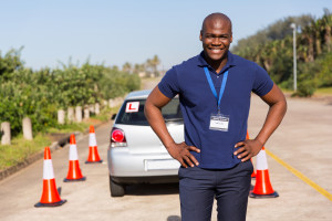 african driving instructor standing in testing ground