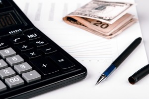 Business Charts with calculator, dollars money and pen on white background