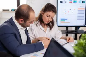 imagem de um profissional analisando documentos financeiros ou gráficos, representando a atuação do Agente de Fiscalização Financeira.