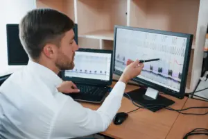 Analista de Controle Interno analisando documentos e gráficos