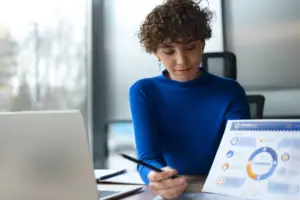 a woman in a blue shirt looking at a piece of paper