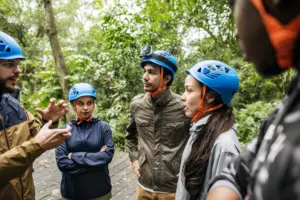 Auxiliar de Turismo e Lazer recebendo turistas e organizando atividades ao ar livre.