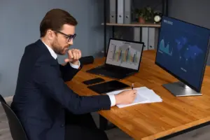 Profissional técnico de controle externo de terno usando notebook e analisando gráficos