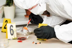 Fotografia de um Auxiliar de Perito em ação, coletando evidências em uma cena de crime ou analisando materiais em laboratório.