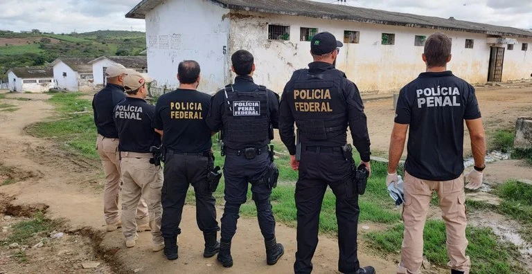 Depen: MGI aprova estrutura da carreira da Polícia Penal Federal! 1 seis policiais penais federais do depen uniformizados de costas em fila