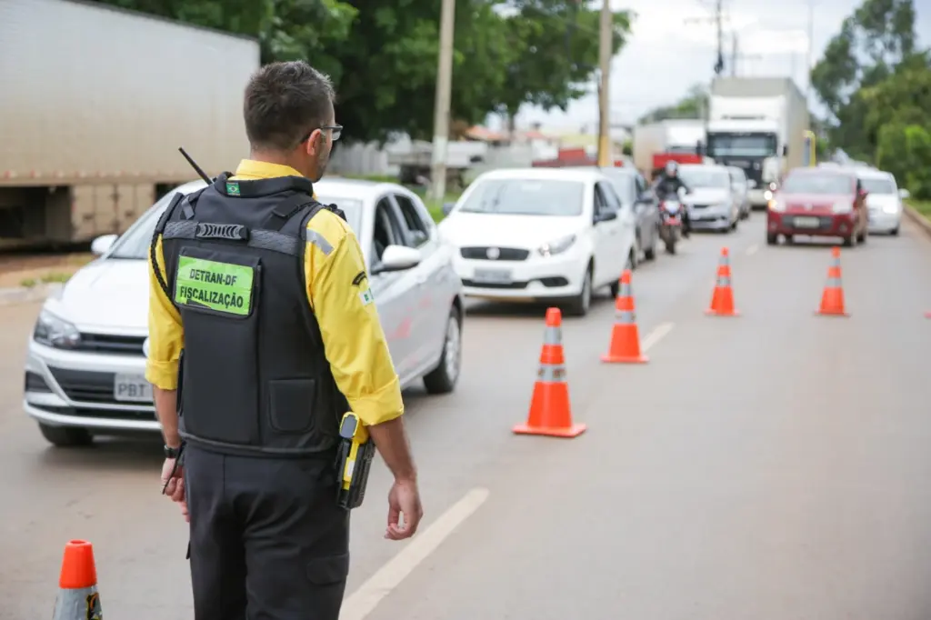 agente de fiscalização de transito do Detran DF trabalhando na pista ao lado de cones