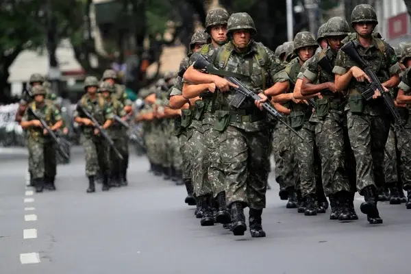 Concursos Militares: Oportunidades para 2024. Editais previstos e com inscrições abertas! 1 servidores do exército andando em fila com porte de arma