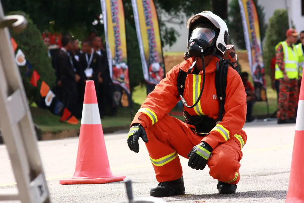 Bombeiro MG abaixado olhando para cima, utilizando uma máscará