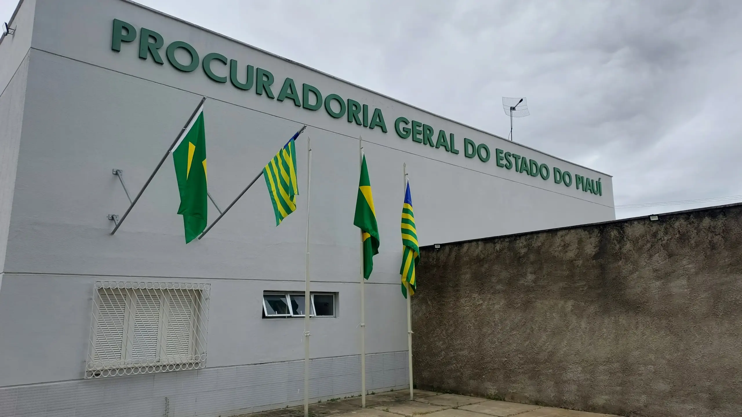 Fachada da Procuradoria Geral do Estado do Piauí, com bandeiras do Brasil e do estado. - Concurso PGE PI