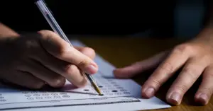Mão de candidato preenchendo gabarito do CNU 2025