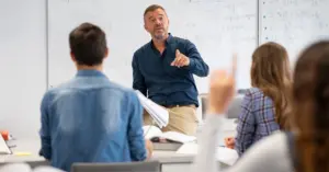 Sala de aula com prefessor ao fundo e alunos / CNU dos professores