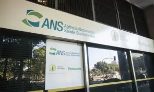 Fachada da Agência Nacional de Saúde Suplementar (ANS) com sinalização de atendimento ao público. - Concurso ANS