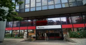 Fachada do prédio do banco BDMG, destacando um letreiro vermelho e branco / Concurso BDMG