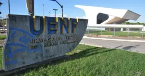 Entrada da Universidade Estadual do Norte Fluminense com prédio ao fundo. / Concurso UENF