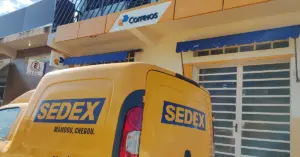 Lateral do carro dos Correios com logo em frente a uma das agências