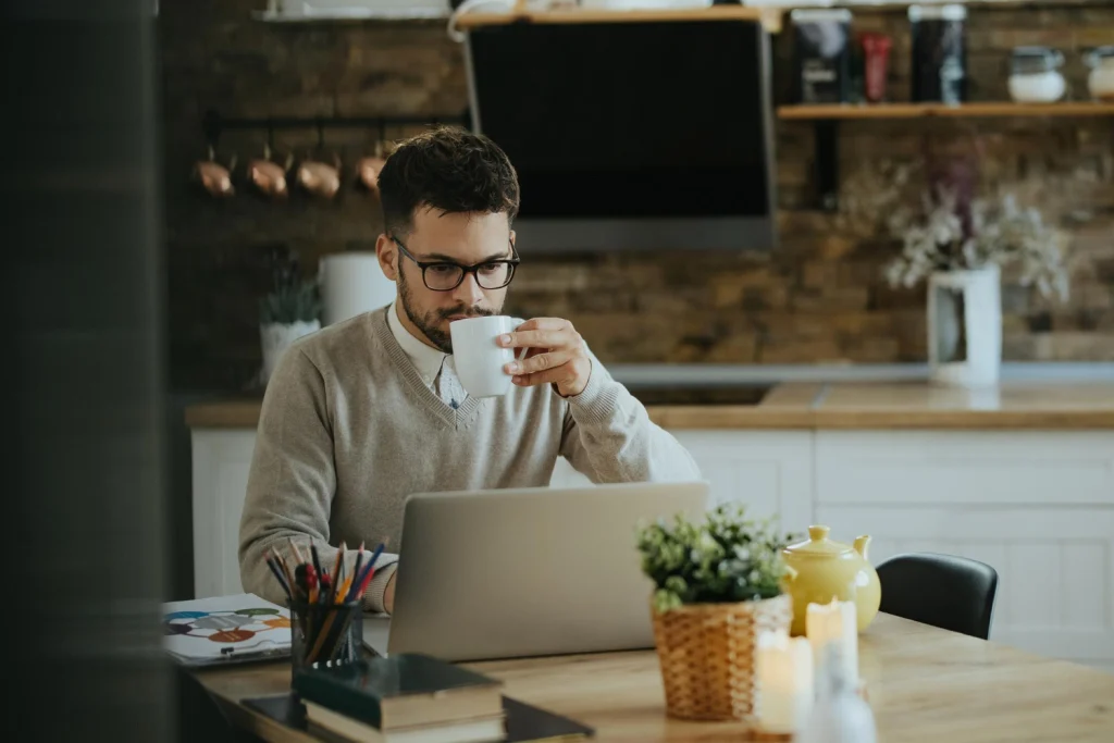 Concurso público Home Office: trabalho remoto e híbrido em 2026! 2 Jovem bebendo café enquanto trabalha home office