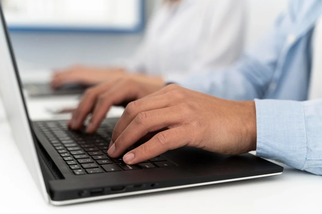 Concurso MP PE: Novo edital com comissão organizadora formada! 1 mãos digitando em notebook representando concurso mp pe