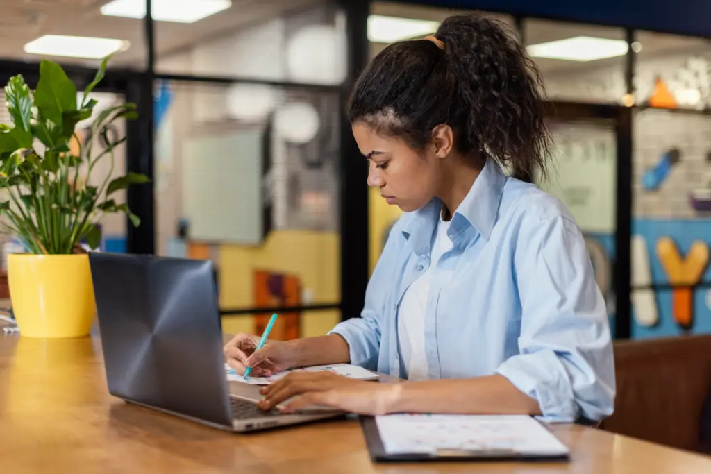 side view woman office working with laptop