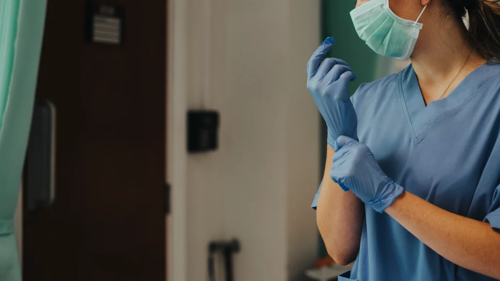 médica colocando luva no hospital representando concurso Ebserh